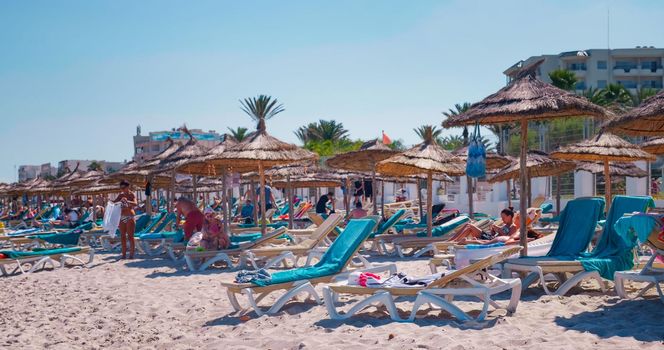 Tunisia, 2022: People relax on Mediterranean Sea beach. Seaside resort. Hotel beach. Vacation concept.