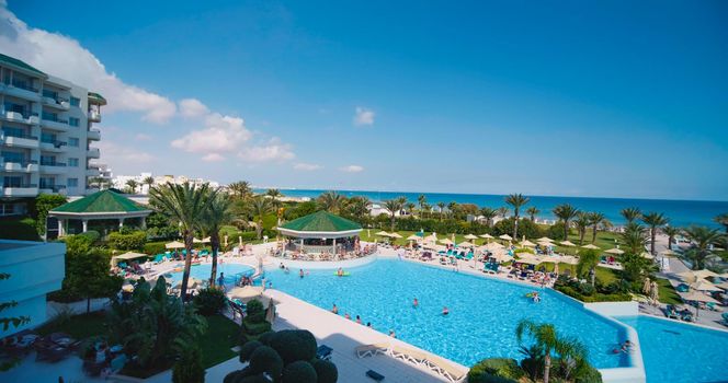 Monastir, Tunisia, 2021: Luxury hotel with tropical garden and swimming pool. Iberostar Selection Diar El Andalous Hotel swimming pool. Top view of pool and lounge area. Tropical vacation concept.