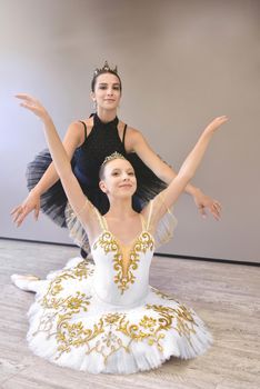 choreographer teacher mentor trainer of classical dance teaches posture help with stretching to young student learn dancing teen girl ballerina