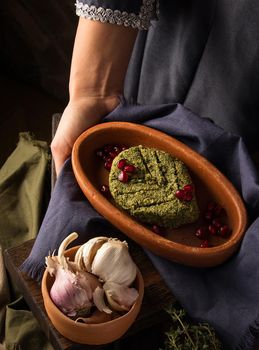 A vertical shot of a waitress presenting a pkhali