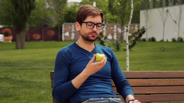 Employee Taking Break Work. Young man Eating a apple as snack. Enjoying an fruit.