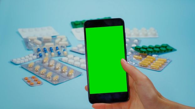 Use phone with Chroma Key Display for Medication Information. Prospectus pills. Using Smarthphone with Mockup, Green Screen Medical. Various Pills blisters.