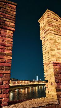 Genova, Italy - July 02, 2022: View of the city and the old harbor (Porto Antico) by night. City lights reflection over the water.