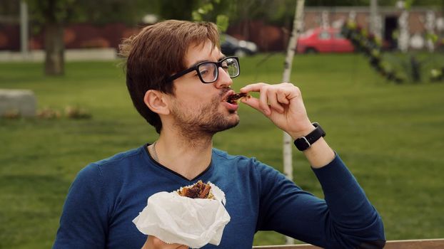 Employee Taking Break Work. Young man Lunch Eating snack. Handsome man enjoying food. Portrait of hungry man. Enjoying food. Smells good snacks.