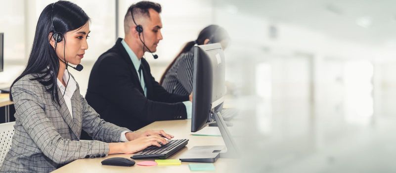 Business people wearing headset working in office to support remote customer or colleague. Call center, telemarketing, customer support agent provide service in broaden view .