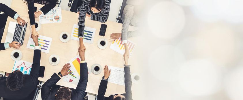 Group business people handshake at meeting table in office together with confident shot from top view . Young businessman and businesswoman workers express agreement of investment deal. broaden view