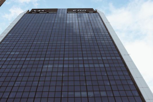 Genova, Italy-January 29, 2022: Beautiful modern high-rise buildings against the sky. 3d illustration on the theme of business success and technology. clouds reflection on the mirror.Industrial zone.