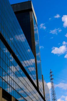 Genova, Italy-January 29, 2022: Beautiful modern high-rise buildings against the sky. 3d illustration on the theme of business success and technology. clouds reflection on the mirror.Industrial zone.