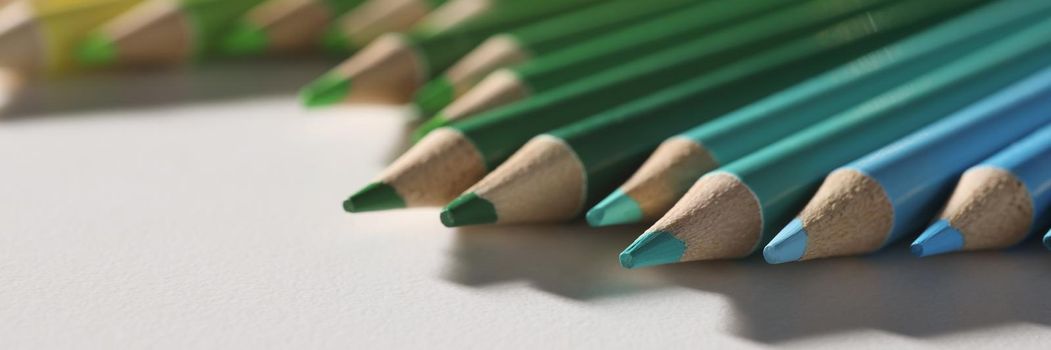 Close-up of colored pencil set loosely arranged on surface and not arranged exactly in row. Tool for drawing your dreams, ideas and vision. Art concept