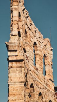 ROME, ITALY - February 05, 2022: Panoramic view around the Colosseum in city of Rome, Italy. Cold and gray sky in the background. Macro photography of the green parks with the old buildings.