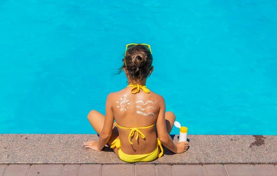 Sunscreen on the back of the child. Selective focus. Kid.