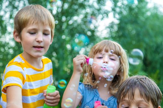 Children blow bubbles in the street. Selective focus. nature.