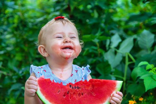 Baby eats watermelon in summer. Selective focus. Food.