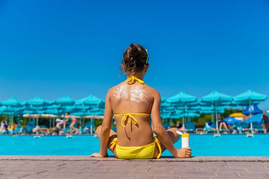 Sunscreen on the back of the child. Selective focus. Kid.
