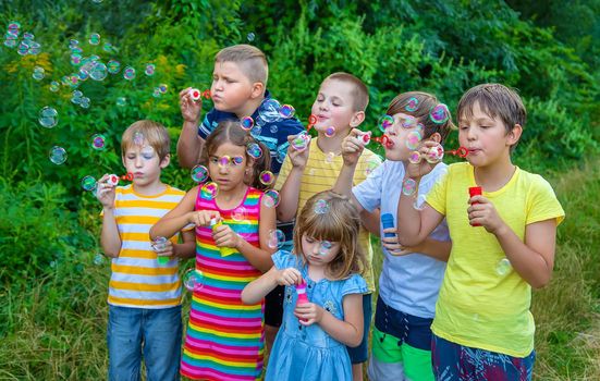 Children blow bubbles in the street. Selective focus. nature.