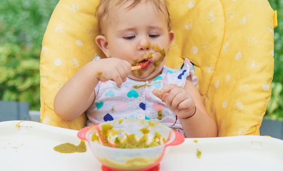 Baby is eating vegetable puree. Selective focus. Child.