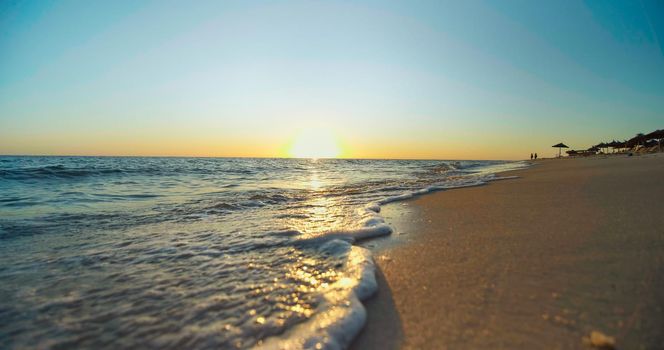 Shining golden waves close up. Sunset on the beach. Beautiful landscape, travel destinations, enjoying holiday, vacation seaside.