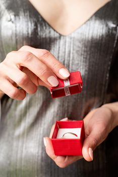 woman hand holding wedding ring in red box, wedding and holidays