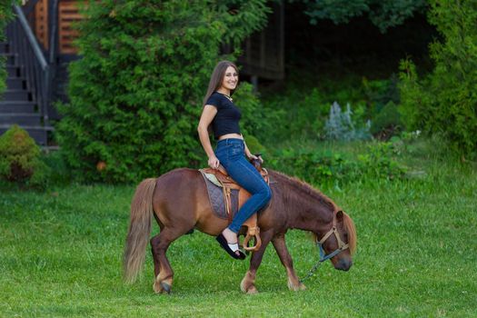 woman riding a pony on the lawn