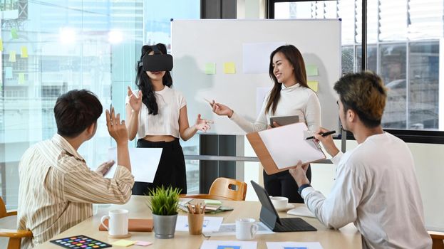 Diverse young startup businesspeople brainstorming in the office and using virtual reality headset.