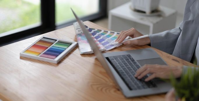 Close-up view of young graphic designer editing his project in comfortable working space.