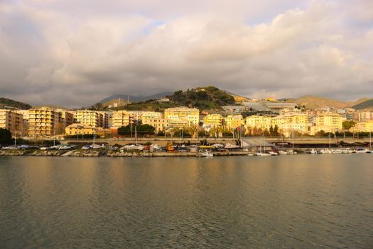 Genova, Italy - July 02, 2022: View of the city and the old harbor (Porto Antico) by night. City lights reflection over the water.