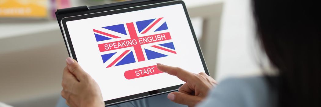 Close-up of lady press on tablet screen learning english language online. Educational process from home, english flag on device. Development, skill concept