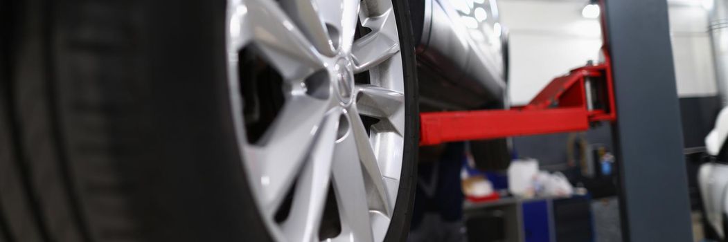 Close-up of automobile tire new changed detail of machine in service centre. Go to car maintenance to change snow tires. Garage, transport service concept