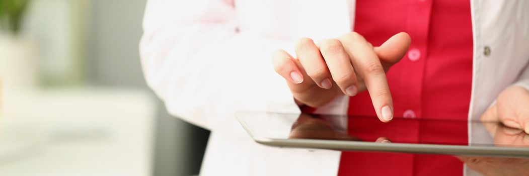 Close-up of professional medical worker use modern tablet device for work. Doctor in uniform with stethoscope hold gadget. Development, medicine concept