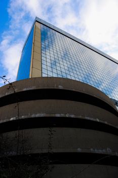 Genova, Italy-January 29, 2022: Beautiful modern high-rise buildings against the sky. 3d illustration on the theme of business success and technology. clouds reflection on the mirror.Industrial zone.