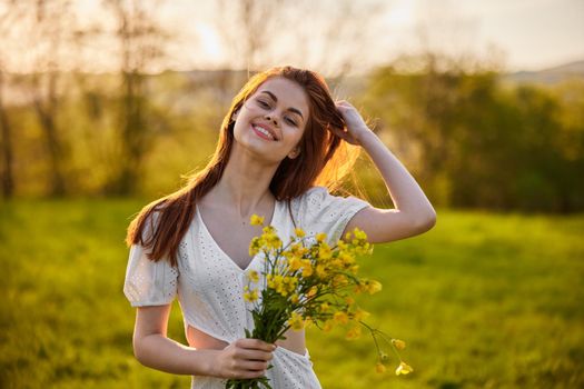 the woman is depicted in the countryside with a bouquet of yellow flowers. High quality photo