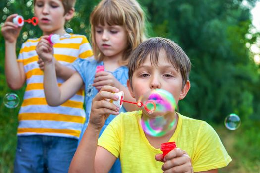 Children blow bubbles in the street. Selective focus. nature.