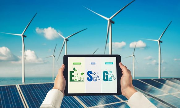 Green business transformation for environment saving and ESG business concept. Businessman using tablet to set corporate goal toward environmental friendly management and alternative clean energy use.