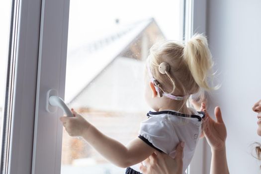 Cochlear implant on baby girl's head. Hearing aid and deafness