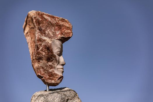 Striking granite statue against a blue sky and sunshine