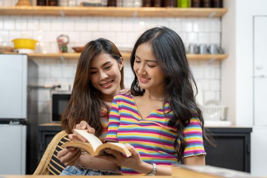 Happy lesbian lgbtq couple in love cuddling, laughing having fun at home. Two diverse pretty affectionate women hugging, bonding. Lgbt relationship concept.