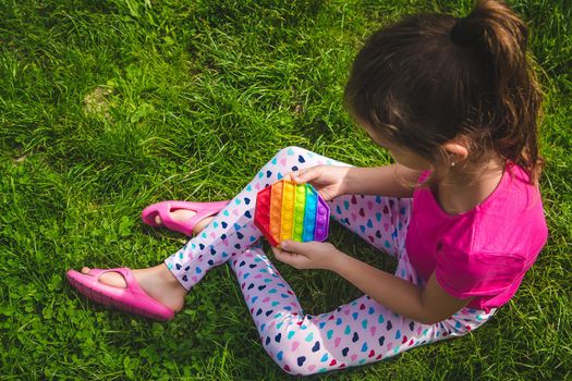 colorful antistress sensory toy fidget push pop it in child hands . Selective focus. nature.