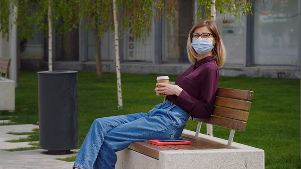 Park woman reading book on bench smiling happy at camera. Pretty young multicultural woman enjoying spring in park.