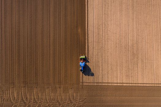 Different shades of brown appear on a field that is plowed with a tractor, Germany