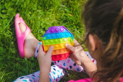 colorful antistress sensory toy fidget push pop it in child hands . Selective focus. nature.