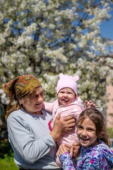 Grandmother holds her granddaughter in her arms. Selective focus. People.