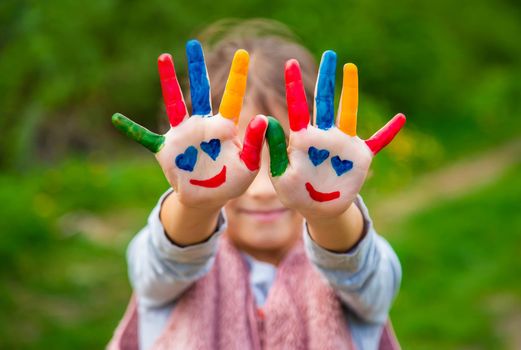 Smile on the hands of a child drawing. Selective focus. Kid.