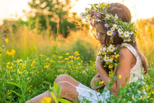 Child girl with wildflowers in summer. Selective focus. Nature.