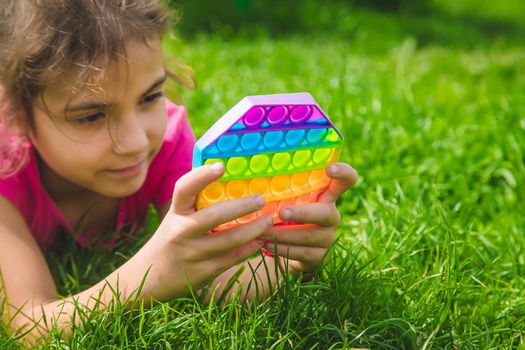 colorful antistress sensory toy fidget push pop it in child hands . Selective focus. nature.