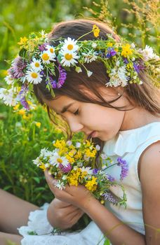 Child girl with wildflowers in summer. Selective focus. Nature.