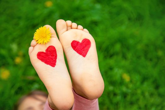 Child feet on the grass in summer. Selective focus. nature.