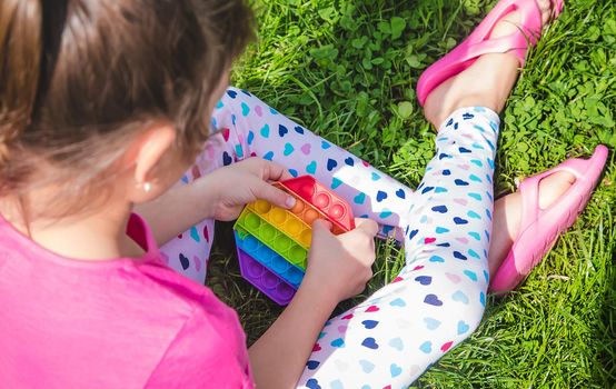colorful antistress sensory toy fidget push pop it in child hands . Selective focus. nature.