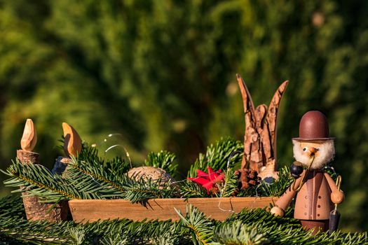 A bowl with decorative elements such as a smoker, an angel and a wooden candle for Christmas