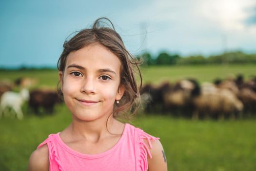 Child with sheep and goats in the meadow. Selective focus. Nature.