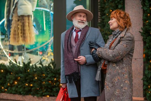 elderly couple on the background of a shop window